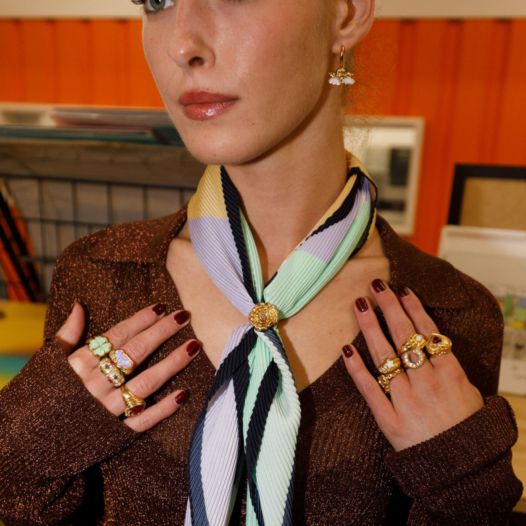 model wearing gold ring stack with opal cherub earrings.