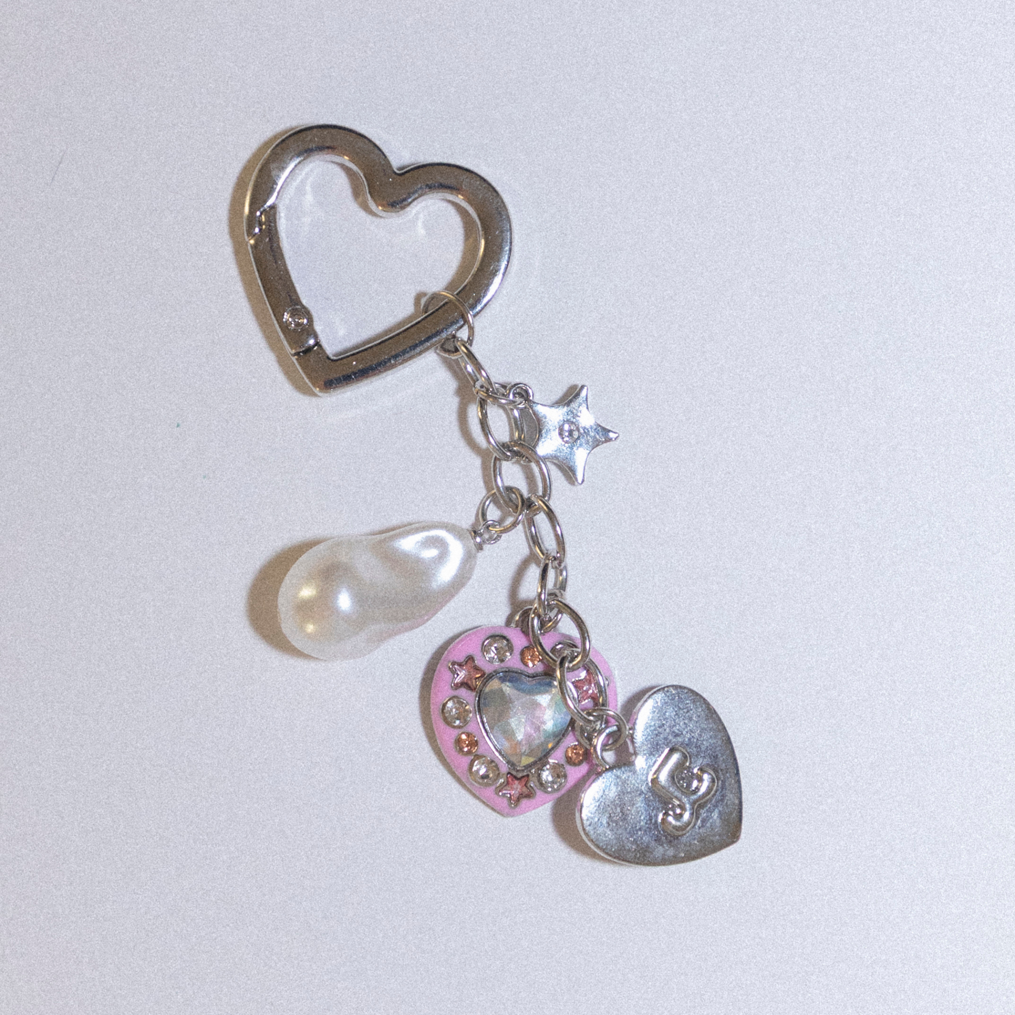 Heart-shaped keychain with heart and pearl charms.