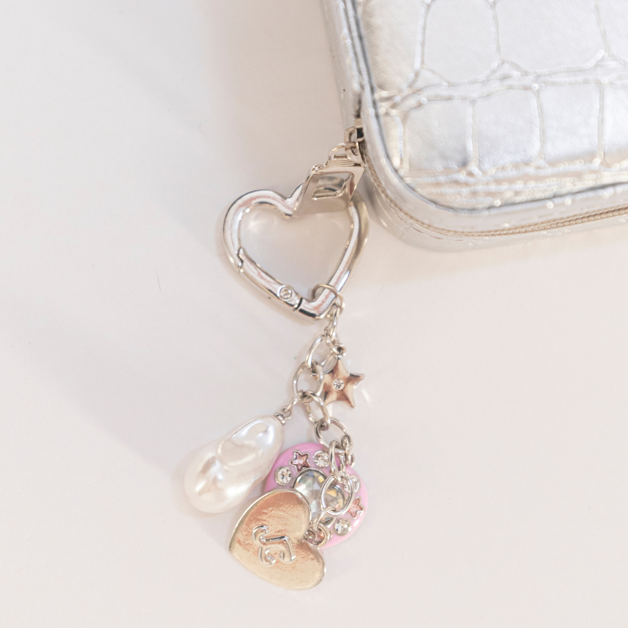 Heart-shaped keychain with heart and pearl charms.