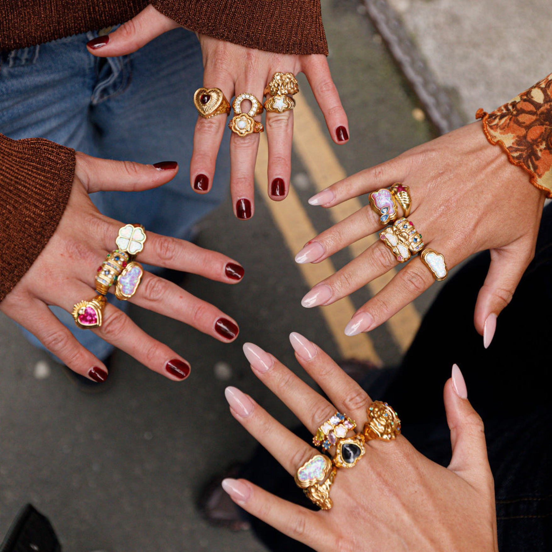 hands wearing many chunky gold july child rings.